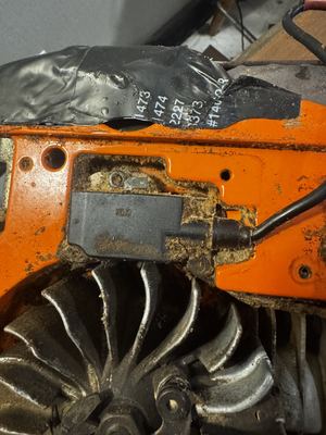 Husqvarna 3120XP Ignition module and flywheel fan, sawdust-loaded — photographed 2026-08-11