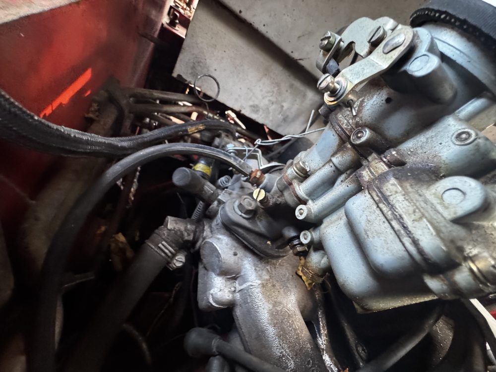 On-engine view of brass idle mixture needle 20, spring 21, and manifold 781F-9425-ACA
