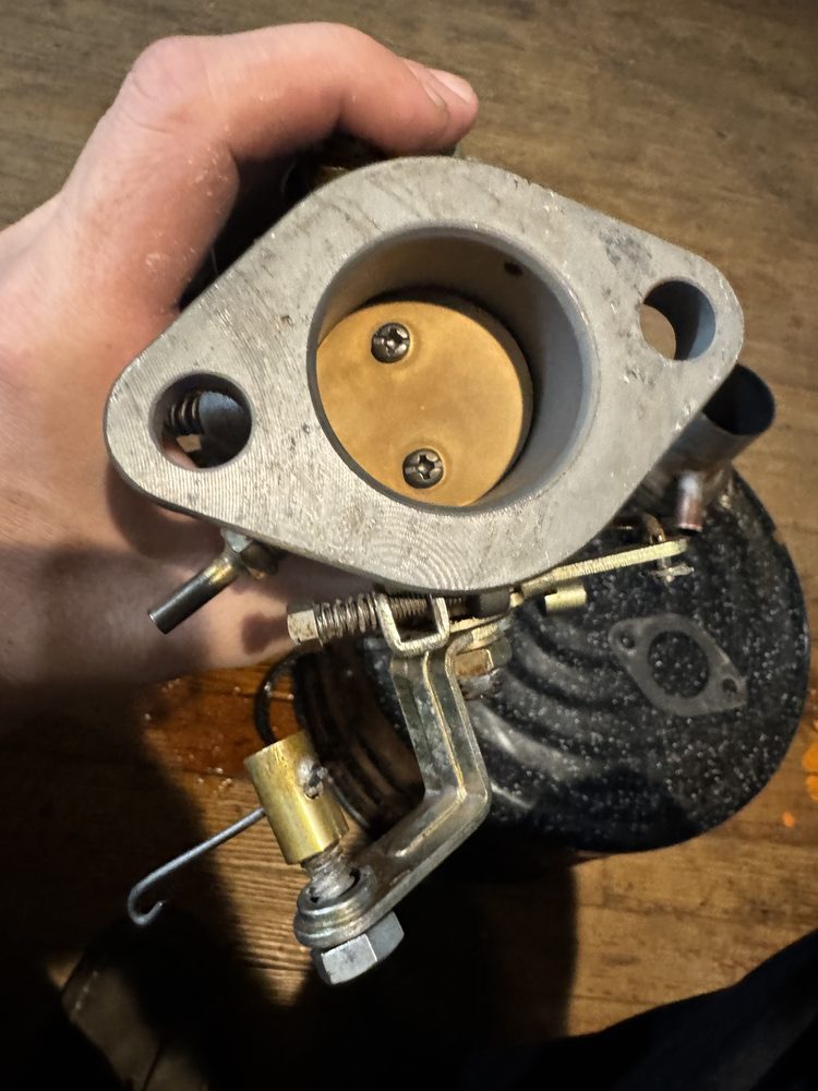 Cast-iron throttle body flange 57 showing brass throttle plate 56 and drilled idle transfer port