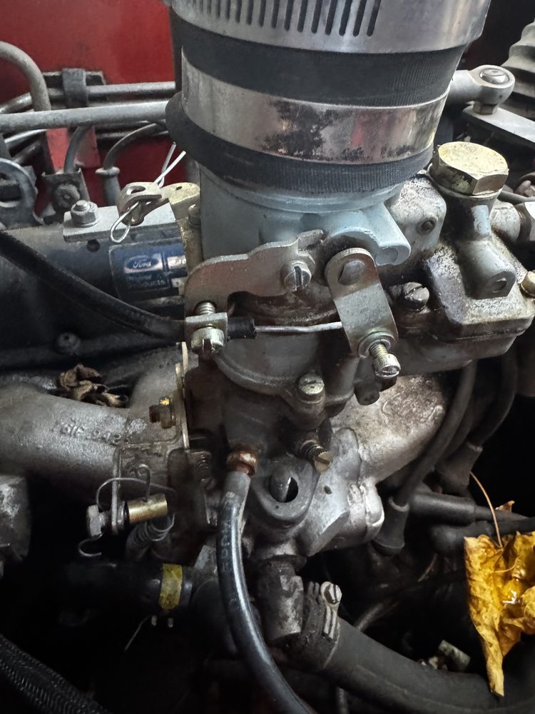 Twisted bailing wire and brass barrel rigged to carburetor throttle arm